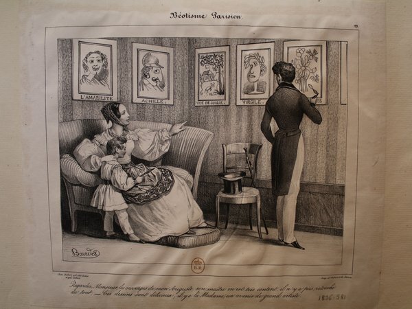 Image depicts an indoor scene with two adults and one child. A woman and a child are sitting on a couch, with the woman pointing towards a wall adorned with framed portraits. Another adult is standing by the wall holding a cane, looking at the pictures, with a top hat placed on a chair beside them.