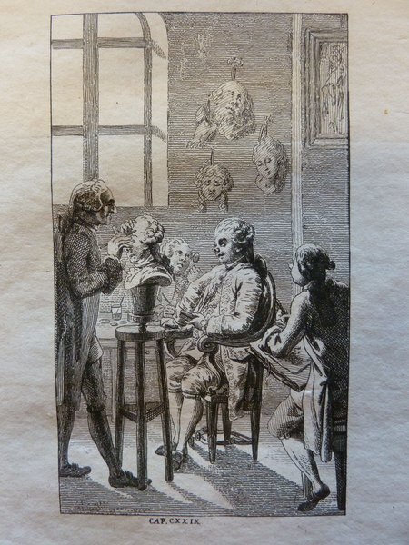 An etching showing a scene in an artist's studio during the Ancien Régime. It features sculptors and painters at work, with wigs and habits à la française visible. The studio is detailed with statues, portraits, and artists’ models. A sculptor can be seen working on a bust, while others converse and study. Light streams through a large window, highlighting the interior.