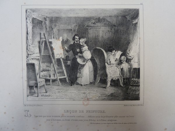 Black and white illustration depicting an indoor scene with several figures. A man with long hair, facial hair, and wearing pince-nez is teaching a woman holding a palette and brushes near an easel; another woman with a child stands nearby a man reading a newspaper. The room includes mahlsticks, paintings, and easels.