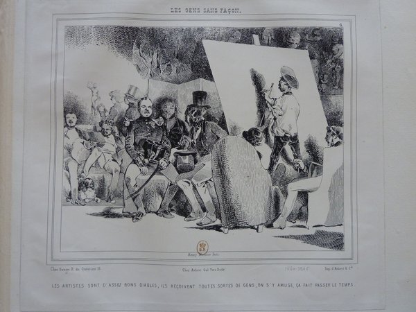 Black and white drawing depicting an artist's studio scene from the July Monarchy era featuring painters with easels and mahlsticks, military uniforms, and bourgeoisie men wearing top hats and long coats. Statues, canes, dogs, and various paintings also populate the space.