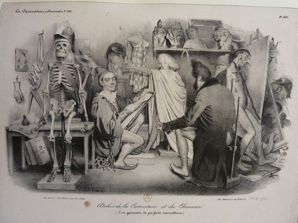 A detailed lithograph from the July Monarchy depicting a busy studio scene filled with caricature and allegorical elements. Various figures including skeletons, mannequins, fools & jesters, and a figure resembling Louis Philippe engaged in artistic creation using easels and lithographic stones. Elements like paintings, statues, and different types of hats, including bicornes, are also present in this cluttered artistic setting.